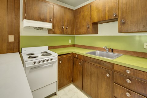 A white stove is in a kitchen with wooden cabinets.