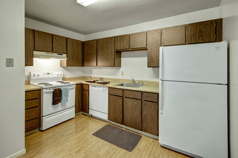 A kitchen with white appliances and wooden cabinets.
