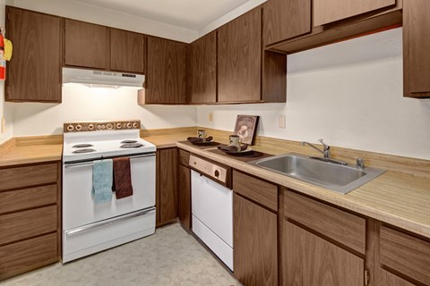 A kitchen with a white oven and sink.