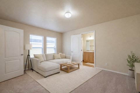 A living room with a white couch and a small wooden table.
