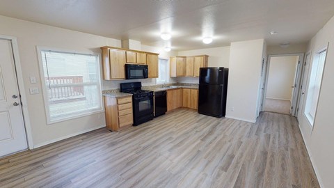 A kitchen with wooden cabinets and black appliances.
