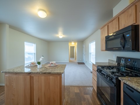 A kitchen with granite countertops and wooden cabinets.
