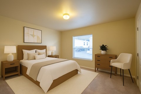 A cozy, well-lit bedroom here at Four Seasons featuring a modern wood bed frame with crisp white bedding, matching nightstands with soft table lamps, neutral wall art above the headboard, plush carpeting, a bright window for natural light, and a dresser with an accent chair creating a calm, inviting retreat.