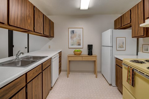 A kitchen with wooden cabinets and a yellow stove.