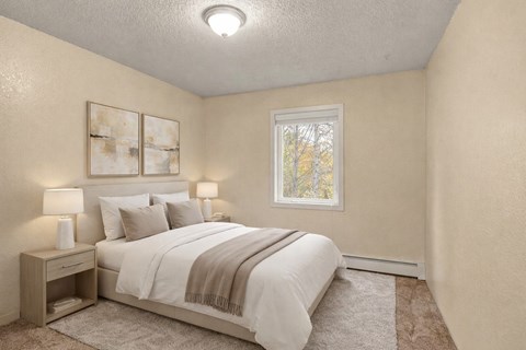 A bedroom with a bed, nightstand, and two framed pictures on the wall.
