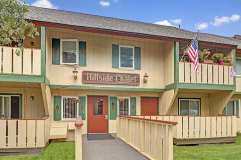 A building with a red door and an American flag on the balcony.