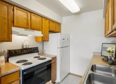 A kitchen with wooden cabinets and a white refrigerator.