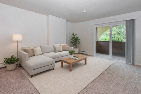 A living room with a grey couch, a small table, and a lamp.