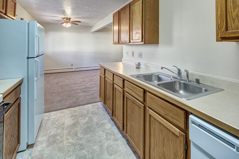 A kitchen with a white refrigerator and wooden cabinets.