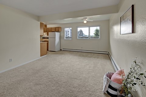 A room with a carpeted floor and a ceiling fan.