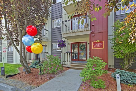 A leasing office is located in a building with a red door and a balcony.