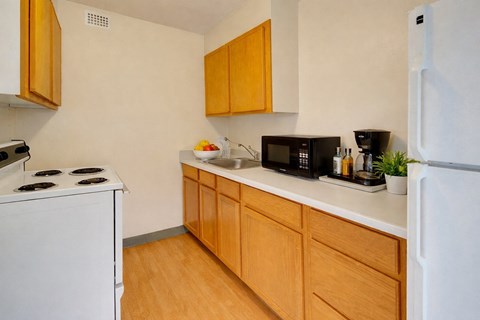 A kitchen with wooden cabinets and white appliances.
