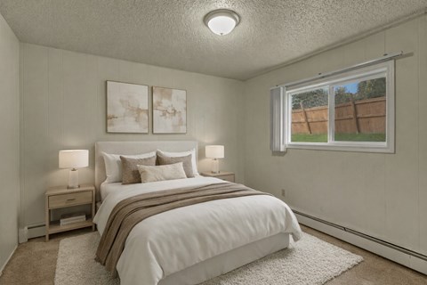 A bedroom with a large bed and two nightstands.