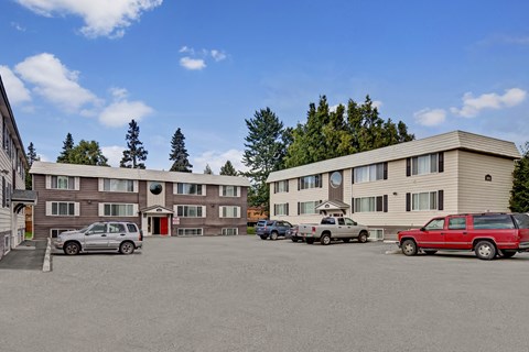 A parking lot with cars and a building in the background.