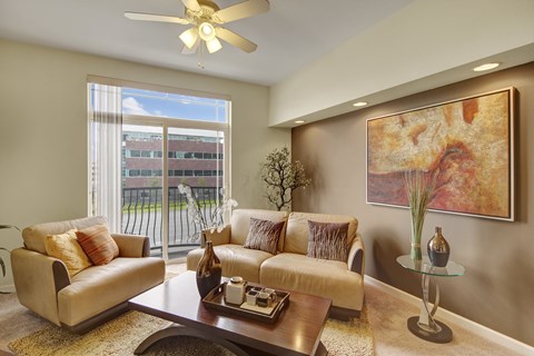 A living room with a couch, a coffee table, and a painting on the wall.