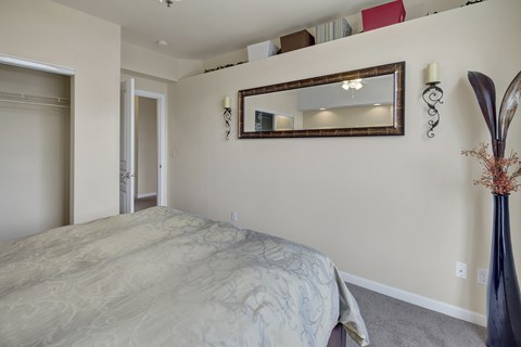 A bedroom with a large bed and a mirror above it.