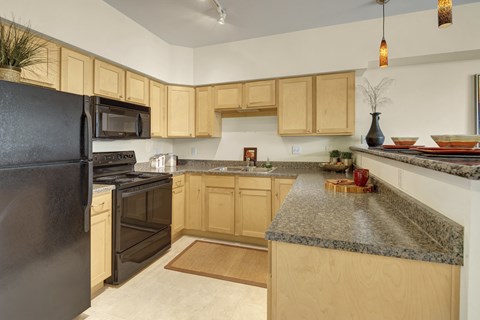 A kitchen with wooden cabinets and granite countertops.
