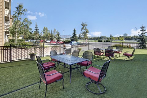A table with chairs is set up on a lawn.