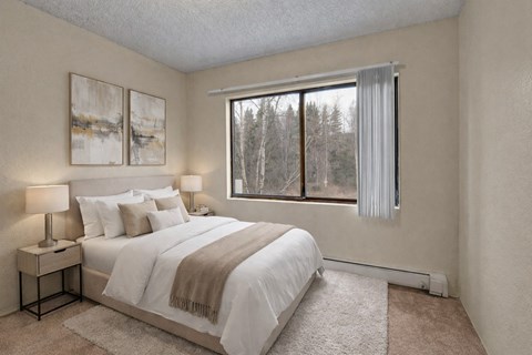 A bedroom with a large bed and two lamps.