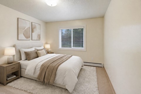 A bedroom with a bed, nightstand, and two framed pictures on the wall.