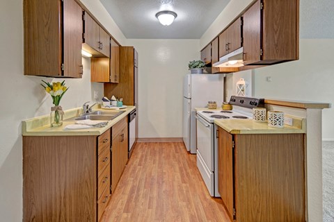 A kitchen with wooden cabinets and a white refrigerator.