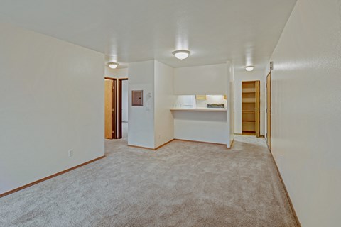 A spacious room with carpeted floor and white walls.