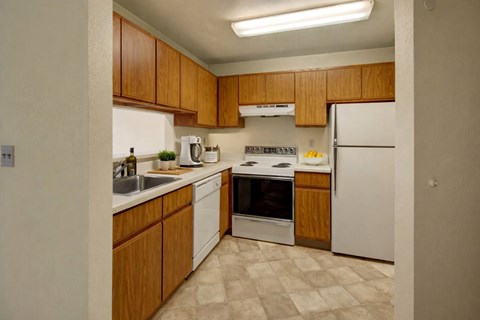 A kitchen with wooden cabinets and white appliances.