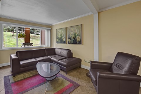 A living room with a brown leather couch, chair, and coffee table.