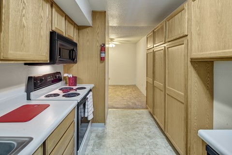 A kitchen with wooden cabinets and a red cutting board.