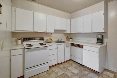 A kitchen with white appliances and cabinets.