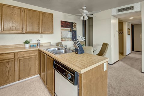 A kitchen with wooden cabinets and a white dishwasher.