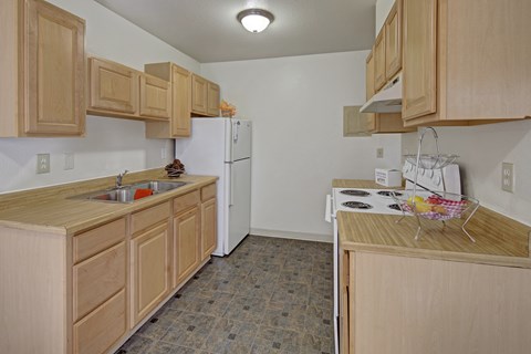 A kitchen with wooden cabinets and a white refrigerator.