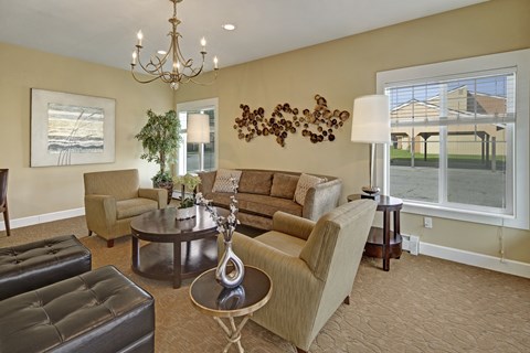 A living room with a couch, chairs, and a chandelier.