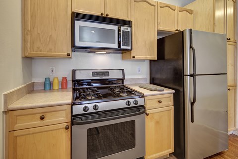 A kitchen with a stove, oven, microwave, and refrigerator.
