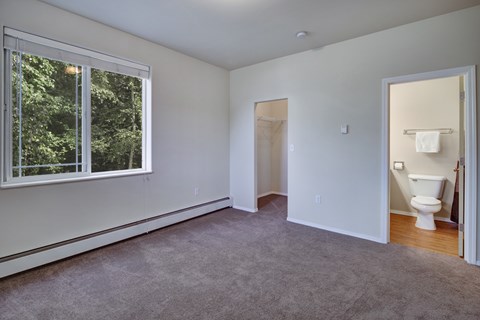 A room with a carpeted floor and a window.