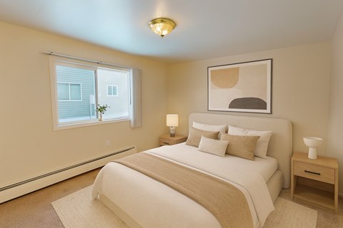 A bedroom with a large bed and a window.