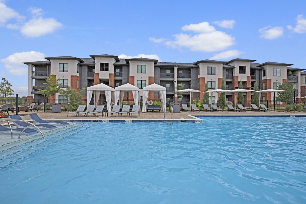 a swimming pool with an apartment building in the background