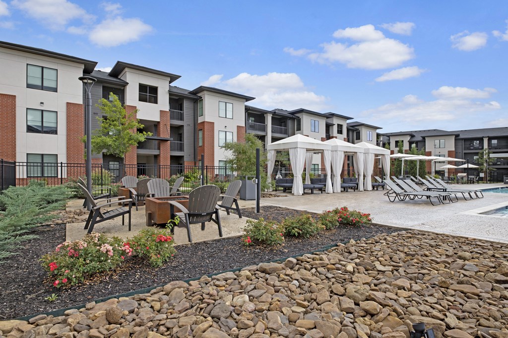an outdoor area with benches and tables and umbrellas in front of a building