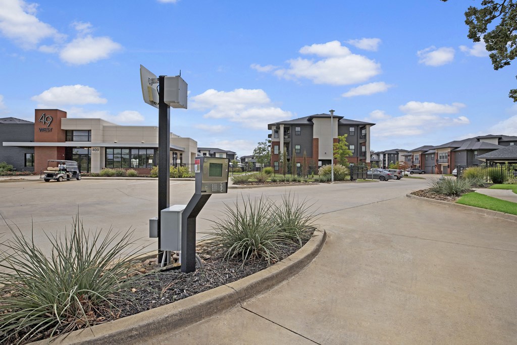 a parking meter on the side of a road with buildings in the background