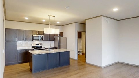 A modern kitchen with dark grey cabinets and a white island.