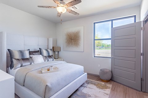 A bedroom with a large bed and a ceiling fan.