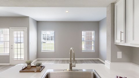 A modern kitchen with a stainless steel sink and a window.