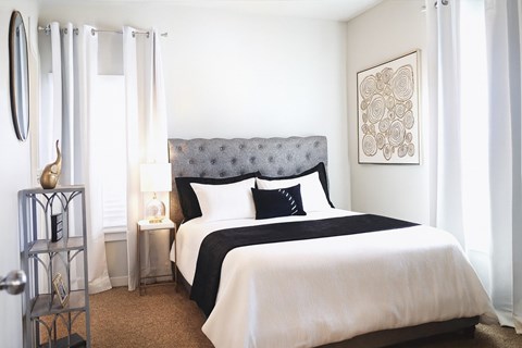 A bedroom with a large bed and a mirror on the wall.
