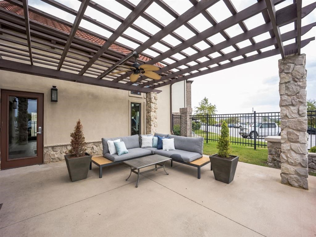 A patio with a couch and a table under a pergola.