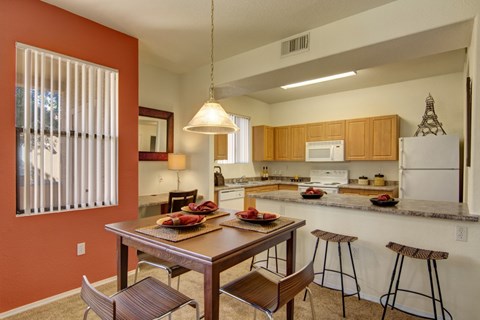 A kitchen with a table and chairs.