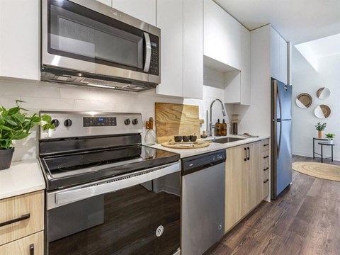 A modern kitchen with a stainless steel oven and microwave.