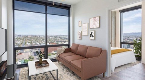A living room with a brown couch and a view of the city.