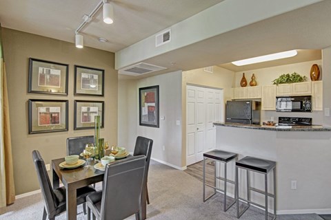 A kitchen with a dining table and chairs.