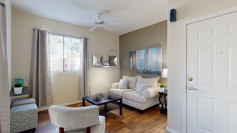 A living room with a white couch and a ceiling fan.