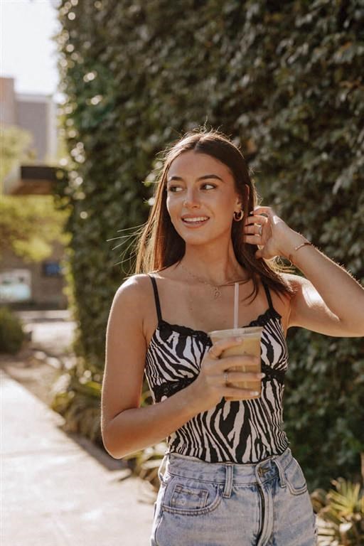 a woman in a zebra print top holding a cup of coffee
